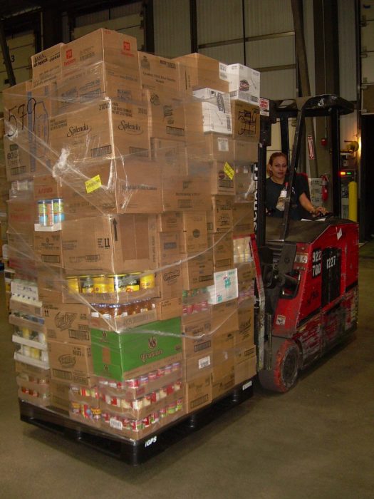 A warehouse forklift moves a pallet of product