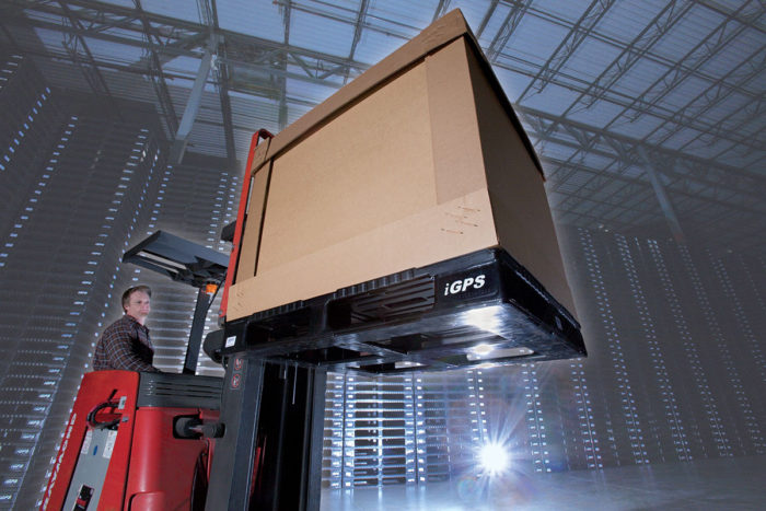 Forklift operator in a large warehouse lifts a plastic pallet. 