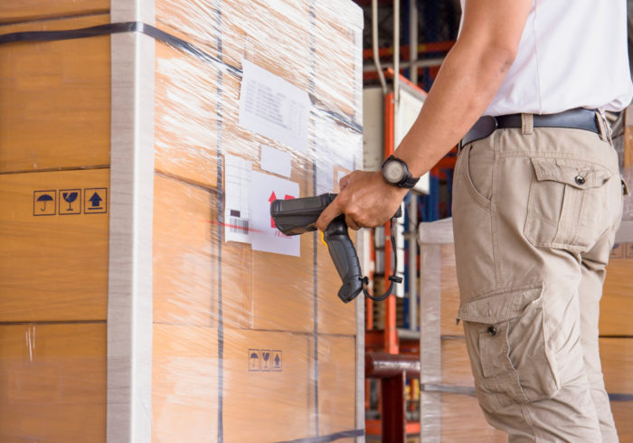 Using a bar code scanner to read a pallet load.