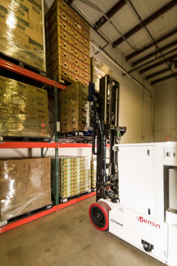 iGPS Plastic Pallets Are Ideal for Automated Storage and Retrieval Systems - Automated Forklift retrieving a pallet of goods off storage rack 
